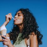 Ragazza che gusta un cucchiaino di gelato