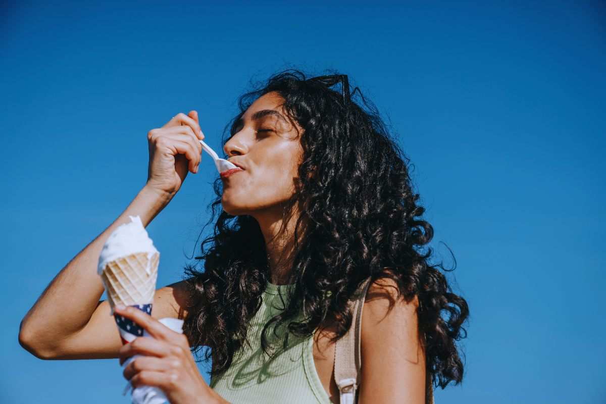 Ragazza che gusta un cucchiaino di gelato