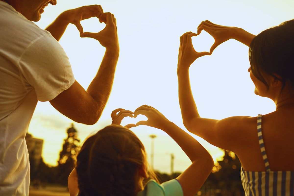 Famiglia che forma cuori con le mani