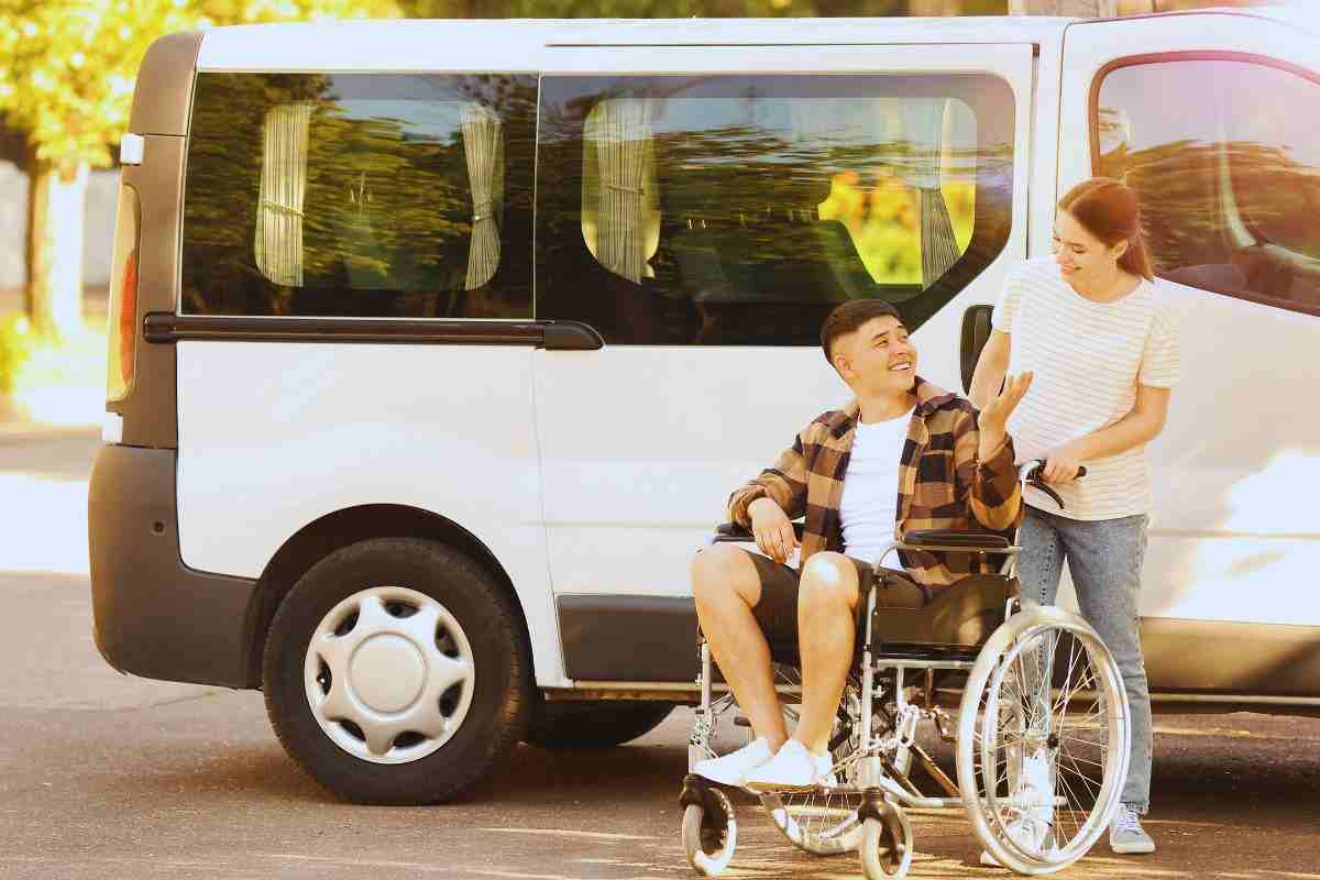 Ragazza che spinge carrozzina disabile 