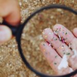 Persona che osserva le microplastiche con la lente d'ingrandimento