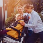 Persone che aiutano una disabile a salire su un veicolo