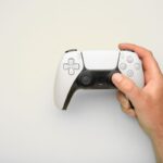 Persona che tiene in mano un dualsense