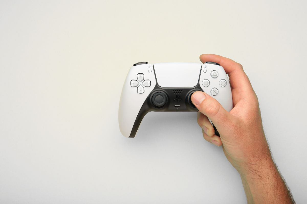 Persona che tiene in mano un dualsense