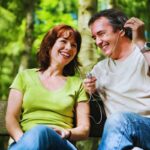 Coppia adulta che ascolta musica in un parco