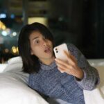 Donna guarda il telefono sconvolta