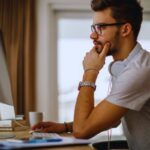 Ragazzo perplesso davanti a monitor computer