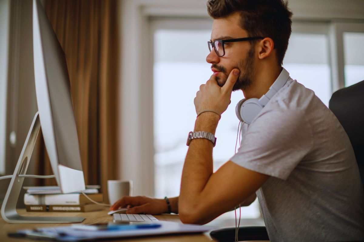 Ragazzo perplesso davanti a monitor computer