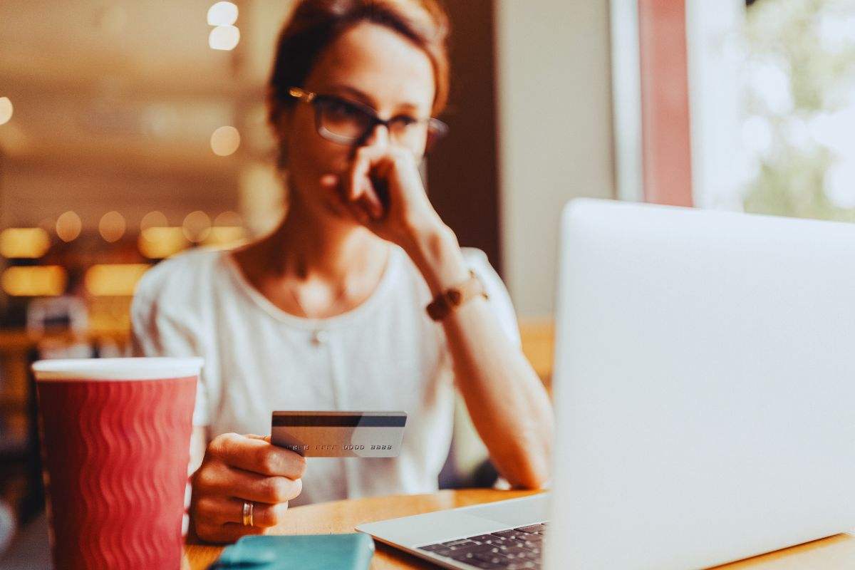 Donna preoccupata con carta di credito in mano