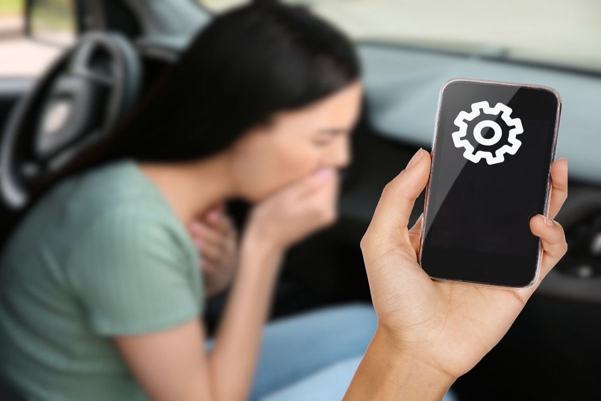 donna con nausea e smartphone tenuto in mano