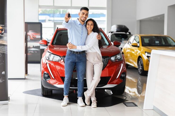 Coppia davanti ad auto nuova dal concessionario 