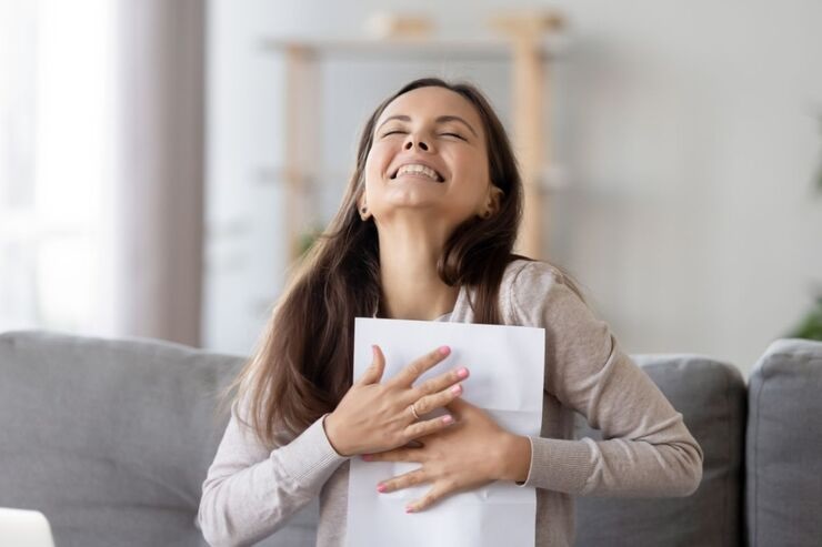 Donna sorridente abbraccia foglio di carta