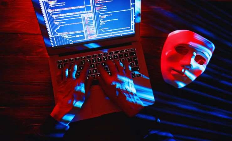 mani su computer e maschera
