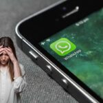 smartphone con whatsapp e donna triste