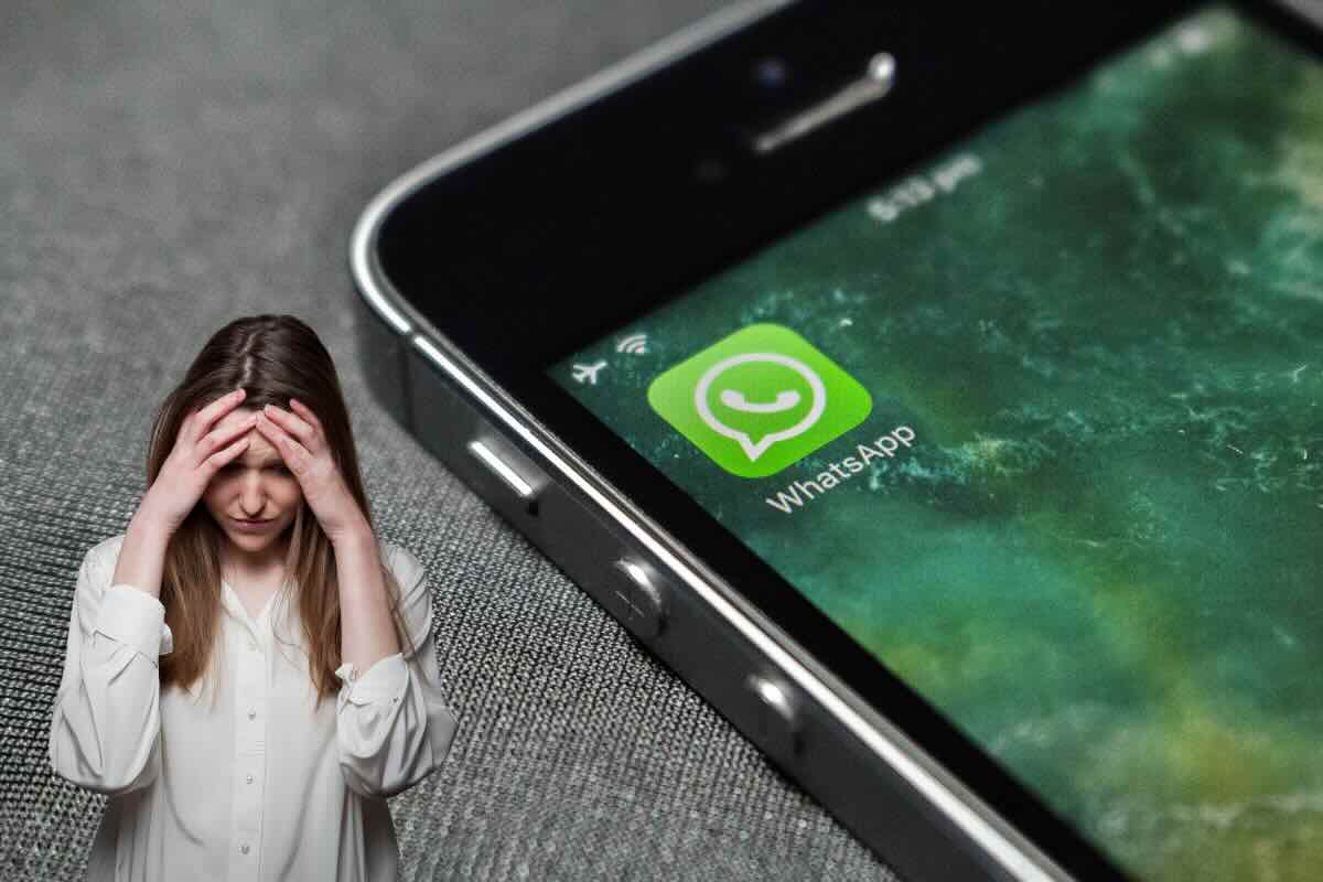 smartphone con whatsapp e donna triste