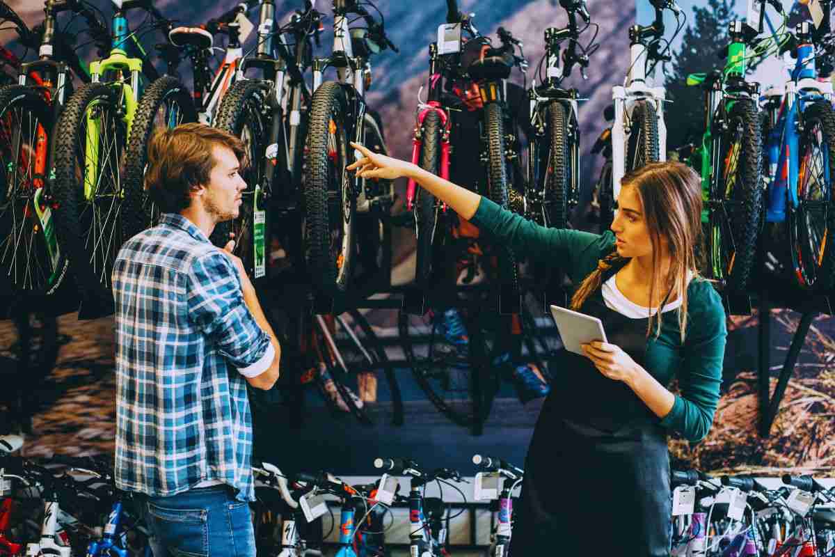 Commessa che indica un modello di bici all'acquirente