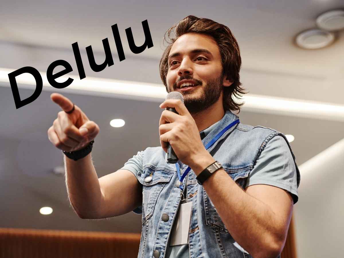 giovane che parla al microfono, scritta delulu